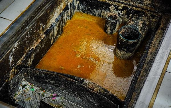 foul odors, slow draining pipes sinks, and visible grease build-up are signs that your grease trap needs cleaning